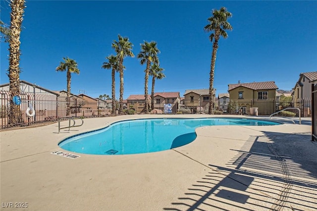 pool featuring a patio area, fence, and a residential view