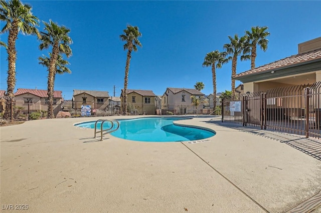 community pool with a residential view, a patio, and fence