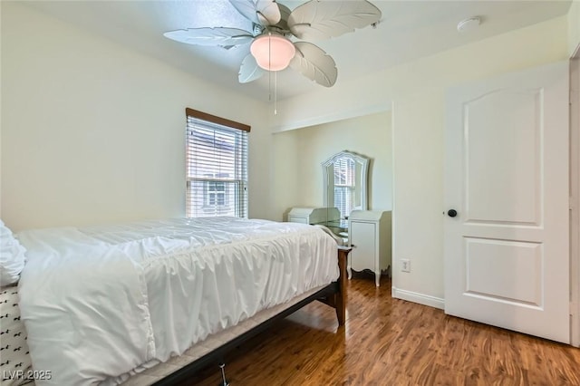 bedroom featuring ceiling fan, baseboards, and wood finished floors