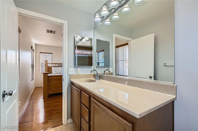 bathroom featuring visible vents, a healthy amount of sunlight, vanity, and wood finished floors