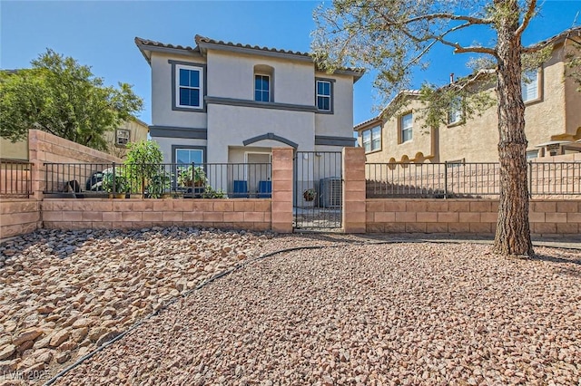 view of front of home with a gate, stucco siding, a fenced front yard, and a tiled roof