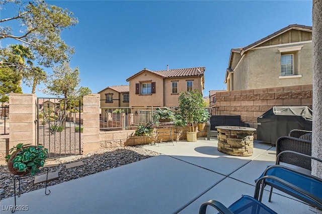 view of patio featuring an outdoor fire pit, a grill, and fence