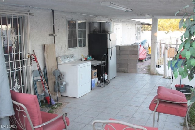 basement featuring washer / clothes dryer and freestanding refrigerator