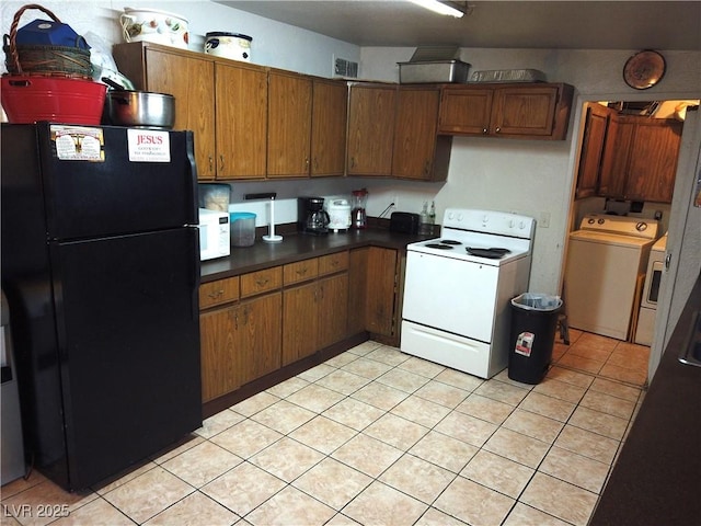 kitchen featuring washer and dryer, white appliances, visible vents, and brown cabinets