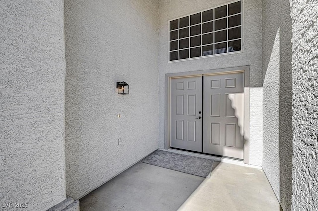 doorway to property featuring stucco siding