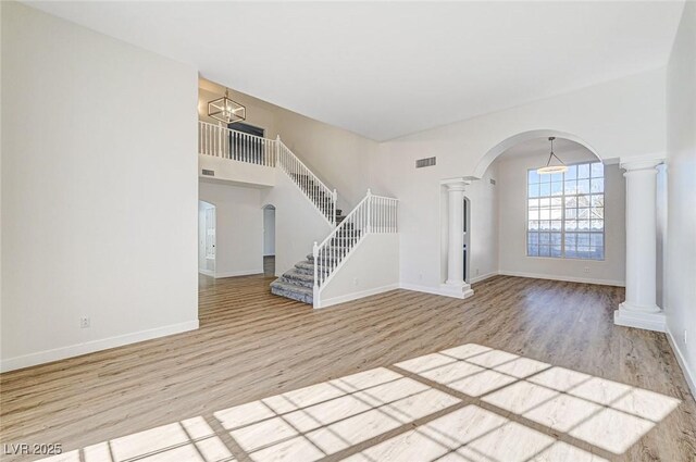 7900 Holly Knoll Ave, Las Vegas, NV 89129 - unfurnished living room featuring visible vents, wood finished floors, decorative columns, and arched walkways