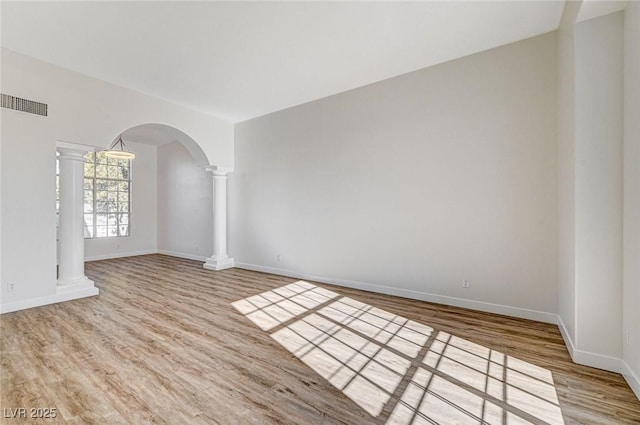 7900 Holly Knoll Ave, Las Vegas, NV 89129 - unfurnished room featuring arched walkways, ornate columns, wood finished floors, baseboards, and visible vents