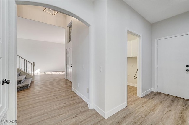 7900 Holly Knoll Ave, Las Vegas, NV 89129 - hallway with baseboards, arched walkways, stairs, and light wood finished floors