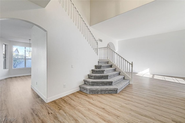 7900 Holly Knoll Ave, Las Vegas, NV 89129 - stairs with baseboards, arched walkways, and wood finished floors