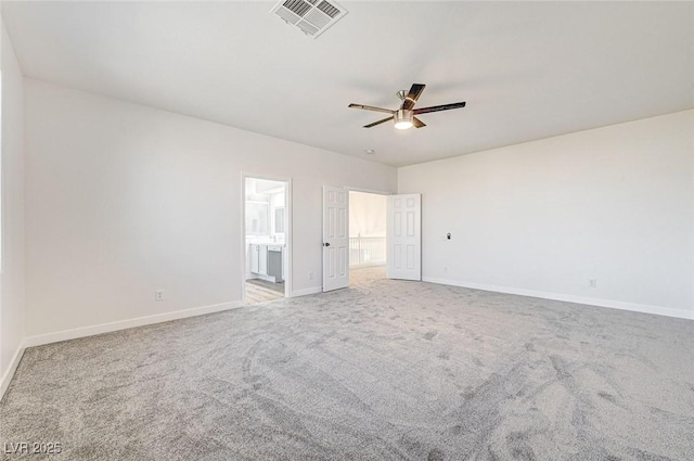 unfurnished bedroom featuring baseboards, visible vents, ceiling fan, ensuite bathroom, and carpet flooring