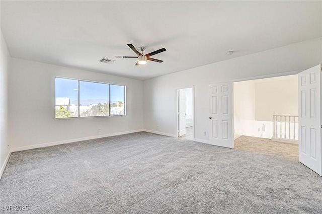 carpeted empty room featuring visible vents, baseboards, and a ceiling fan