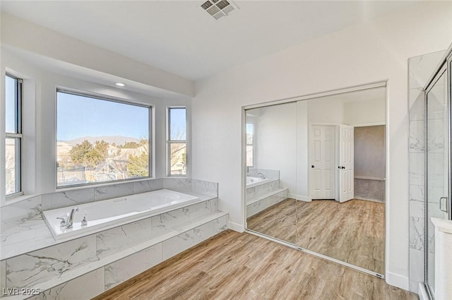 7900 Holly Knoll Ave, Las Vegas, NV 89129 - bathroom with wood finished floors, a shower stall, a bath, baseboards, and visible vents