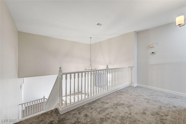 carpeted empty room featuring visible vents and baseboards