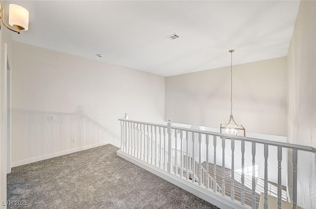 corridor with an upstairs landing, visible vents, carpet flooring, and baseboards