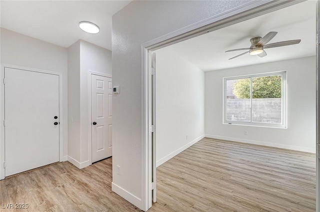 interior space featuring baseboards, light wood-type flooring, and ceiling fan