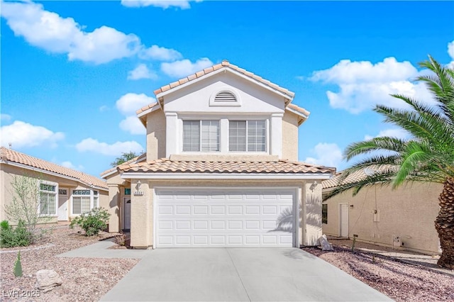 mediterranean / spanish home featuring concrete driveway, a tiled roof, an attached garage, and stucco siding