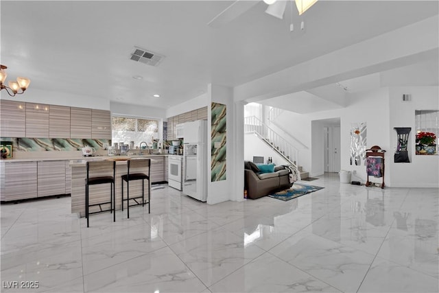 interior space featuring open floor plan, modern cabinets, visible vents, and marble finish floor