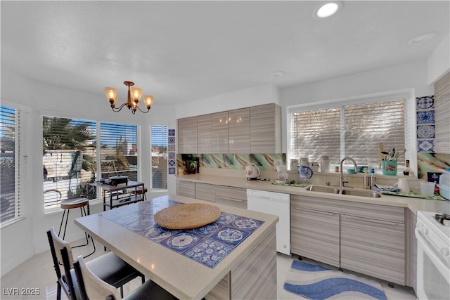 kitchen with a wealth of natural light, white appliances, modern cabinets, and a sink