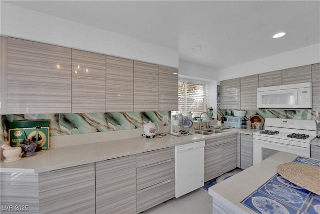 kitchen featuring modern cabinets, a sink, recessed lighting, white appliances, and light countertops