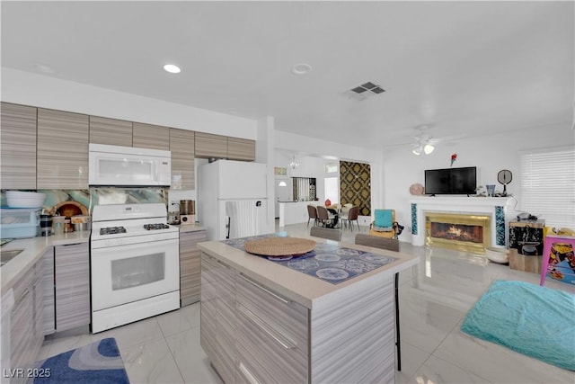 kitchen with white appliances, a ceiling fan, light countertops, modern cabinets, and marble finish floor