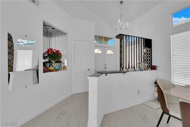 interior space featuring baseboards, a notable chandelier, marble finish floor, and high vaulted ceiling