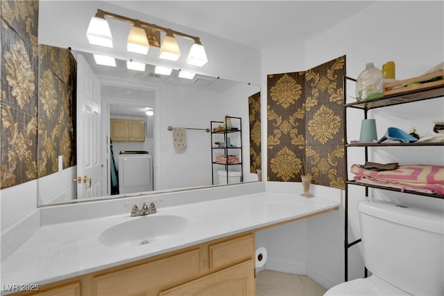 bathroom with washer / dryer, toilet, and vanity