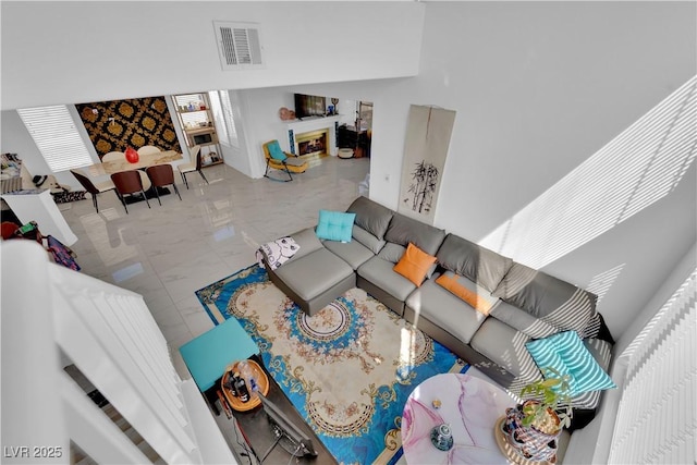 living area with visible vents and marble finish floor