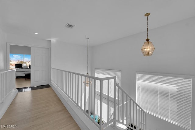 corridor featuring light wood-style flooring and visible vents