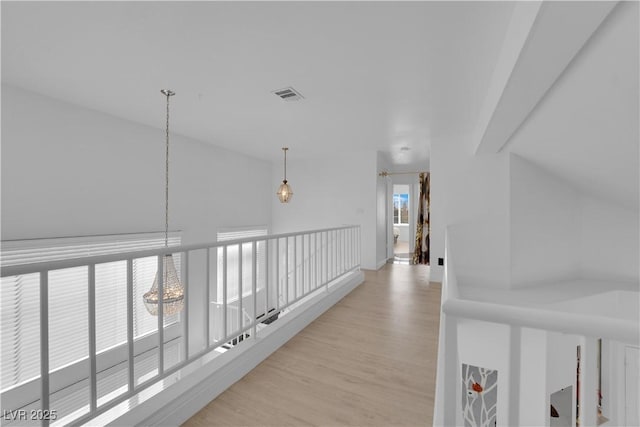 hall with light wood-style floors and visible vents