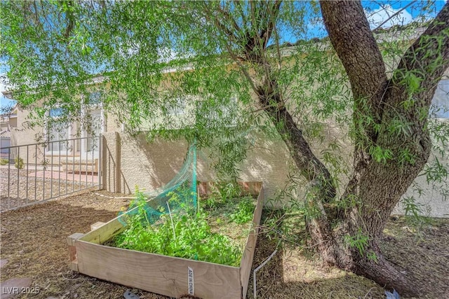 view of yard featuring fence and a garden