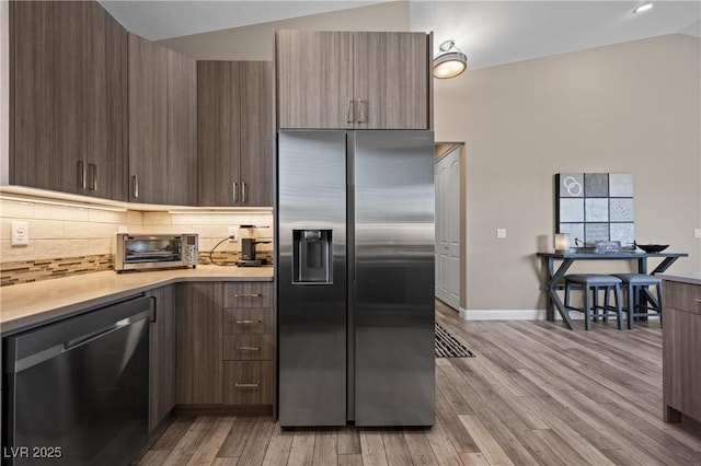 kitchen with light countertops, a toaster, modern cabinets, and stainless steel appliances