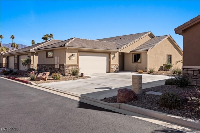 view of front of home featuring concrete driveway, a tile roof, stucco siding, stone siding, and an attached garage