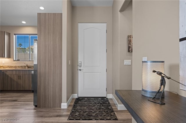 foyer with recessed lighting, baseboards, and wood finished floors