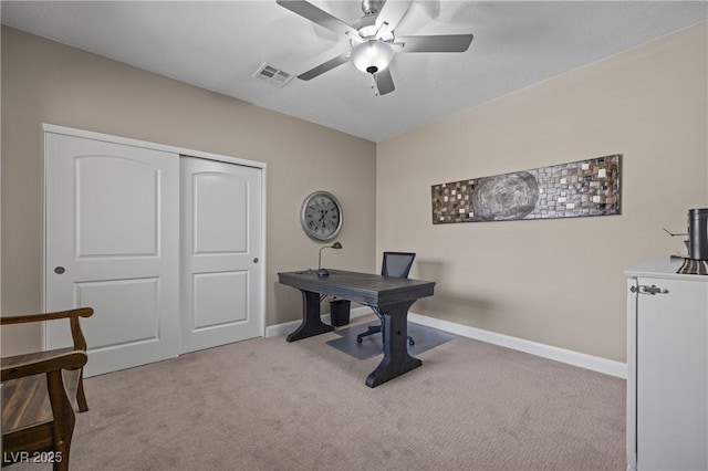 carpeted office space featuring baseboards, visible vents, and ceiling fan