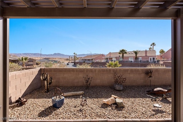 view of yard with a mountain view, a residential view, and a fenced backyard