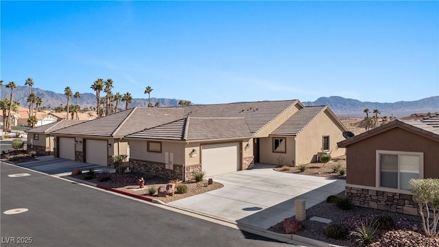 ranch-style home with stone siding, a mountain view, and a garage