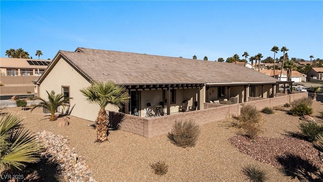 exterior space with a patio, fence, and stucco siding