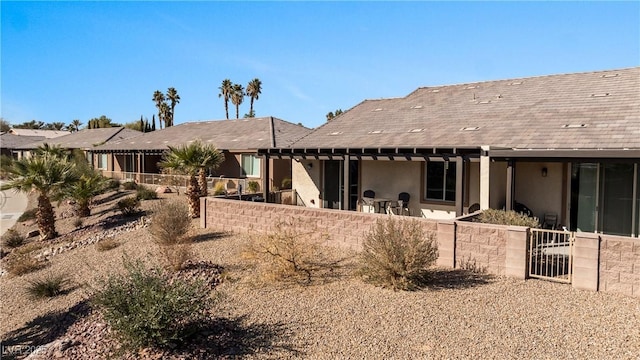 back of property featuring stucco siding, a patio, and fence