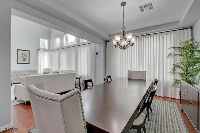 dining space with visible vents, an inviting chandelier, and dark wood-style floors