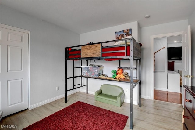 bedroom with wood finished floors and baseboards