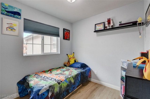 bedroom featuring baseboards and wood finished floors