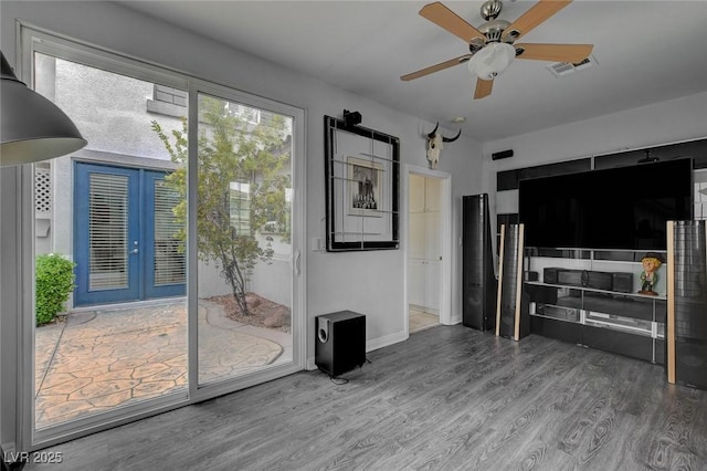 living room featuring visible vents, french doors, ceiling fan, and wood finished floors