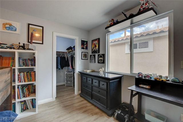 interior space with baseboards and light wood-type flooring