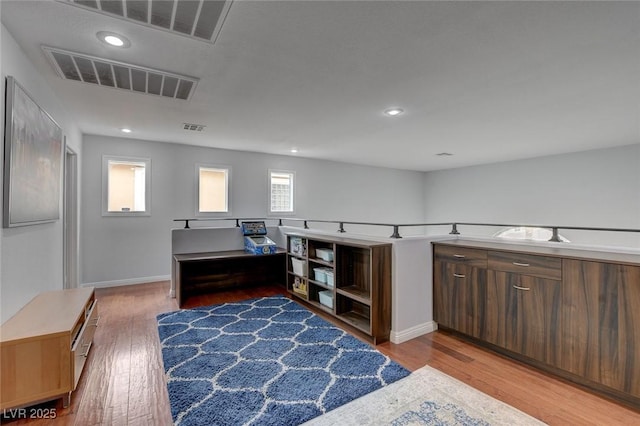 office space featuring recessed lighting, wood finished floors, and visible vents