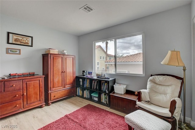 living area with visible vents and light wood-style flooring