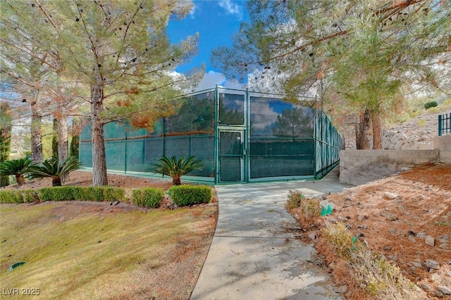 view of tennis court with a gate and fence