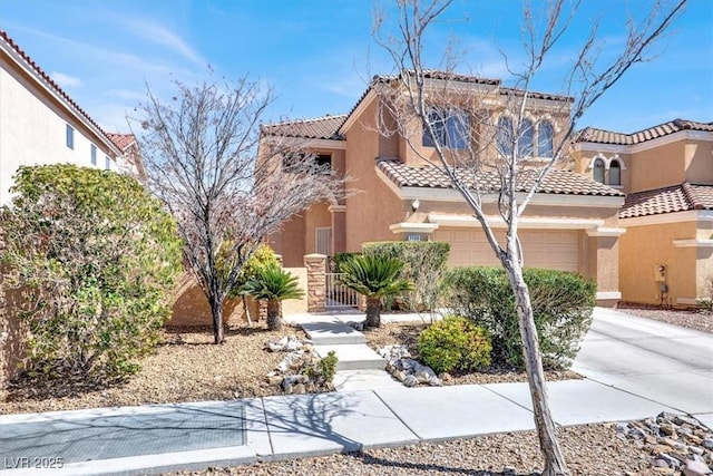 mediterranean / spanish house featuring stucco siding, concrete driveway, and a tile roof