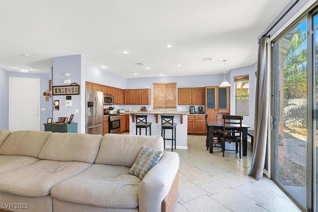 living room with light tile patterned floors, visible vents, and recessed lighting