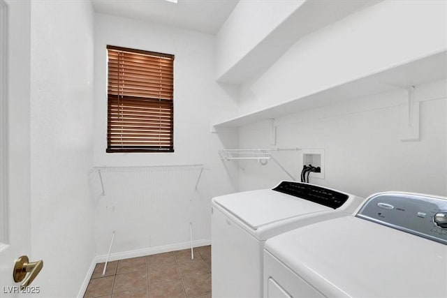 washroom with light tile patterned floors, baseboards, separate washer and dryer, and laundry area