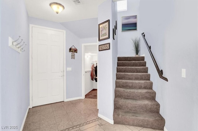 foyer entrance featuring visible vents, baseboards, and stairs